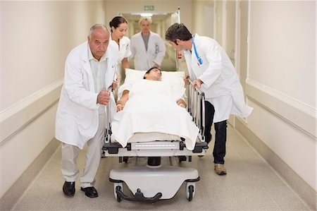 simsearch:649-02666333,k - Doctors rushing patient down hallway Stock Photo - Premium Royalty-Free, Code: 6122-08212138