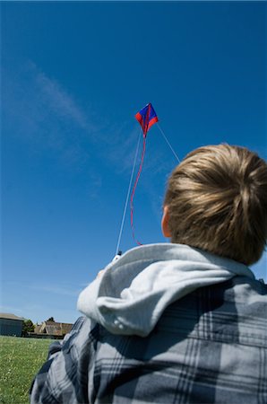 simsearch:6102-06336642,k - Boy flying a kite in field Foto de stock - Sin royalties Premium, Código: 6122-08212213