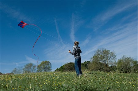 simsearch:6102-06336642,k - Boy flying a kite in field Foto de stock - Sin royalties Premium, Código: 6122-08212211