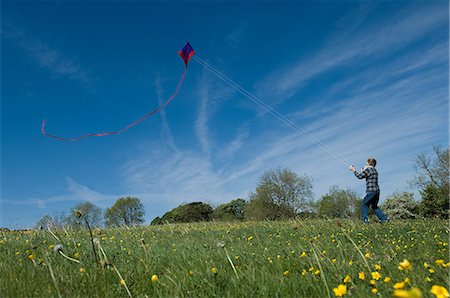 Boy flying a kite in field Stock Photo - Premium Royalty-Free, Code: 6122-08212212