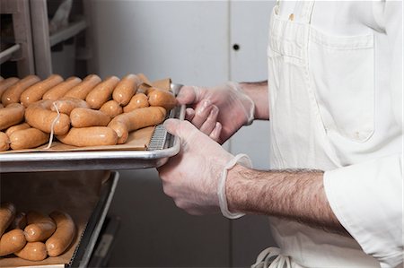 Butcher with tray of sausages Photographie de stock - Premium Libres de Droits, Code: 6122-08212445