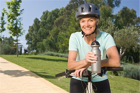 simsearch:693-03707361,k - Mature woman cyclist wearing helmet and holding bottle Photographie de stock - Premium Libres de Droits, Code: 6122-08212484