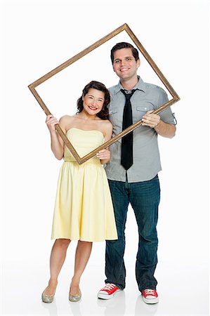 simsearch:614-06896896,k - Young couple holding picture frame against white background Foto de stock - Sin royalties Premium, Código: 6122-08212577