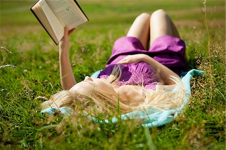 reading book open air - Young woman lying down reading a book in a field Stock Photo - Premium Royalty-Free, Code: 6122-08212642