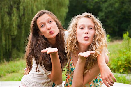 Two teenage girls fooling around in the countryside and blowing kisses Stock Photo - Premium Royalty-Free, Code: 6122-08212627