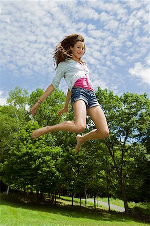 Teenage girl bouncing high in the air in the countryside Foto de stock - Sin royalties Premium, Código: 6122-08212635