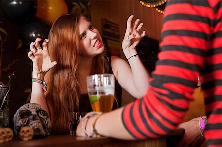 snarling - Young woman pulling faces at friend in bar Stock Photo - Premium Royalty-Free, Code: 6122-08212762