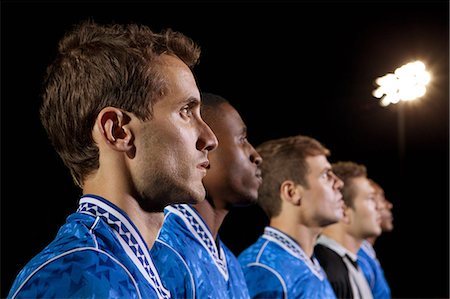 Soccer players standing in line on pitch at night Stock Photo - Premium Royalty-Free, Code: 6122-08212773