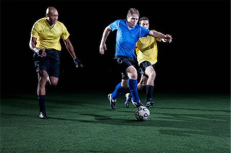 simsearch:6122-07697777,k - Soccer players tackling on pitch Photographie de stock - Premium Libres de Droits, Code: 6122-08212772