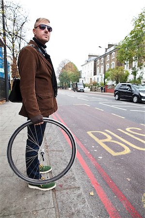 Cyclist holding bike wheel Stock Photo - Premium Royalty-Free, Code: 6122-08212782