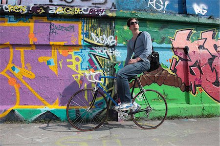 simsearch:6113-08171317,k - Mid adult cyclist sitting by graffiti Stock Photo - Premium Royalty-Free, Code: 6122-08212794