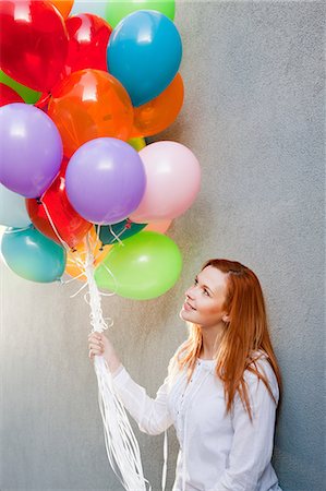 simsearch:6122-08212873,k - Young woman with bunch of balloons Stock Photo - Premium Royalty-Free, Code: 6122-08212849