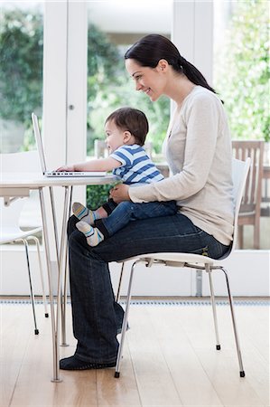 Young woman and baby son using laptop Stock Photo - Premium Royalty-Free, Code: 6122-08212882