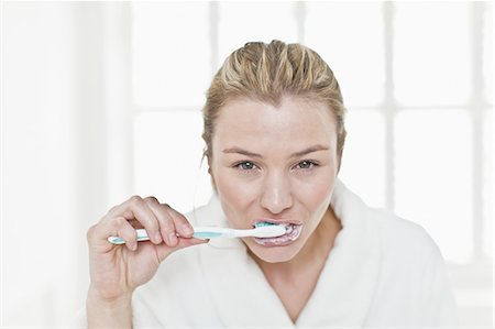 simsearch:6108-05870746,k - Woman brushing her teeth in bathroom Stock Photo - Premium Royalty-Free, Code: 6122-08229122