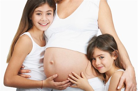 standing girl side view - Girls hugging pregnant mother's belly Photographie de stock - Premium Libres de Droits, Code: 6122-08229399