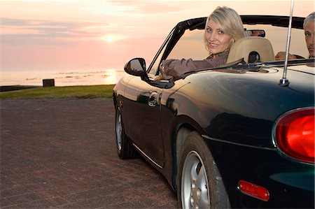 Woman sitting in convertible at sunset Photographie de stock - Premium Libres de Droits, Code: 6122-08229307