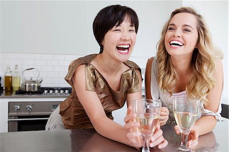 Laughing women drinking wine together Stock Photo - Premium Royalty-Free, Code: 6122-08229332