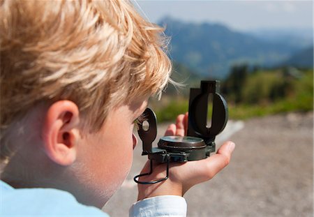 Boy using compass outdoors Photographie de stock - Premium Libres de Droits, Code: 6122-08229336