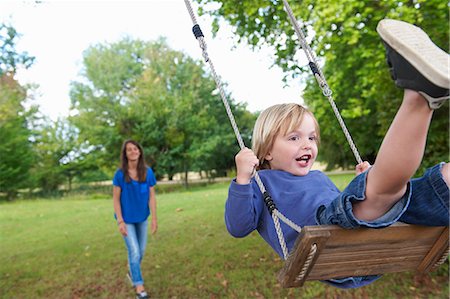 pushing kids on a swing - Boy playing on swing in backyard Photographie de stock - Premium Libres de Droits, Code: 6122-08229461