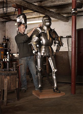 Blacksmith crafting armor in shop Photographie de stock - Premium Libres de Droits, Code: 6122-08229435