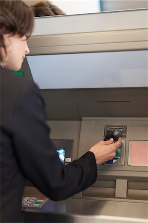Businesswoman using ATM outdoors Stock Photo - Premium Royalty-Free, Code: 6122-08229522