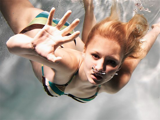 Swimming woman reaching out Stock Photo - Premium Royalty-Free, Image code: 6122-08229643