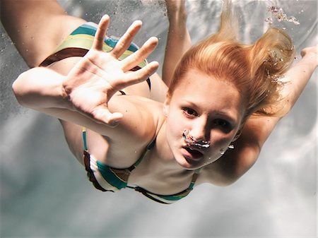swimsuit underwater posing - Swimming woman reaching out Stock Photo - Premium Royalty-Free, Code: 6122-08229643