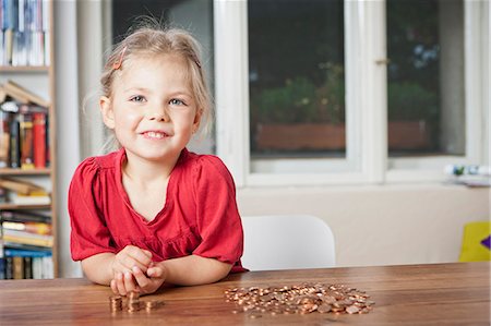 penny - Girl playing with pennies at table Stock Photo - Premium Royalty-Free, Code: 6122-08229749