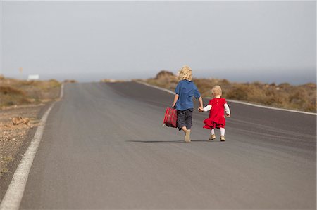 simsearch:632-07674621,k - Siblings walking together on rural road Fotografie stock - Premium Royalty-Free, Codice: 6122-08229755