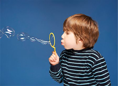 Close up of boy blowing bubbles Stock Photo - Premium Royalty-Free, Code: 6122-08229768