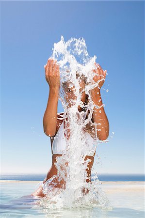 simsearch:649-05820140,k - Woman splashing in swimming pool Stock Photo - Premium Royalty-Free, Code: 6122-08229739