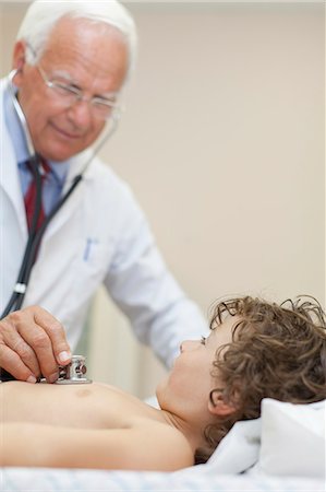 pediatrician stethoscope - Doctor examining boy in office Stock Photo - Premium Royalty-Free, Code: 6122-08229880