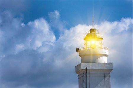 simsearch:632-05991653,k - Lighthouse shining against blue sky Photographie de stock - Premium Libres de Droits, Code: 6122-08229822