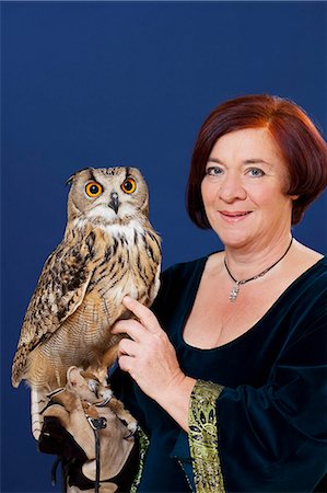 simsearch:649-06113680,k - Trainer holding owl on arm Fotografie stock - Premium Royalty-Free, Codice: 6122-08229932