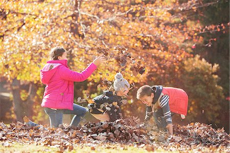 pile leaves playing - Boys and girl playing in autumn leaves Stock Photo - Premium Royalty-Free, Code: 6124-08170349