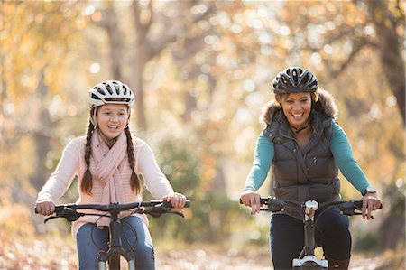 simsearch:6124-08170436,k - Smiling mother and daughter bike riding outdoors Stock Photo - Premium Royalty-Free, Code: 6124-08170394