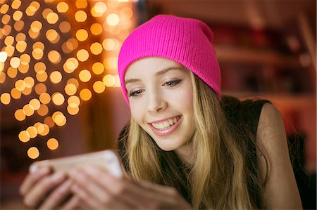 simsearch:6124-08170579,k - Teenage girl in pink beanie texting with cell phone Photographie de stock - Premium Libres de Droits, Code: 6124-08170484