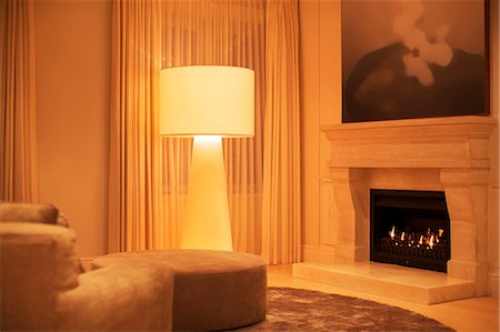 simsearch:6113-06753907,k - Illuminated floor lamp next to marble fireplace Stock Photo - Premium Royalty-Free, Code: 6124-08170495