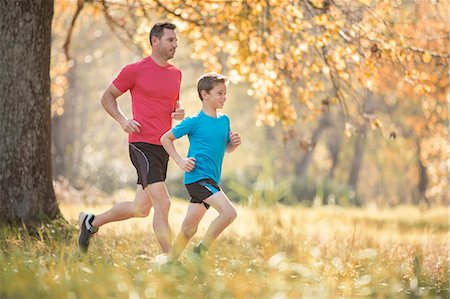 side - Father and son jogging in autumn park Stock Photo - Premium Royalty-Free, Code: 6124-08170417