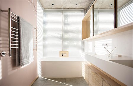 Light shining through blinds behind soaking tub in luxury bathroom Fotografie stock - Premium Royalty-Free, Codice: 6124-08170672