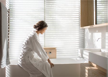 simsearch:6113-07790501,k - Woman in bathrobe drawing a bath in soaking tub in luxury bathroom Stock Photo - Premium Royalty-Free, Code: 6124-08170697