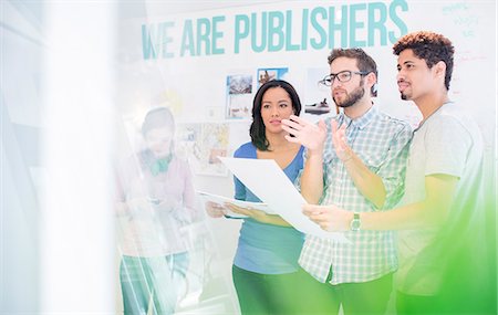 Publishers reviewing and discussing proofs in office Stock Photo - Premium Royalty-Free, Code: 6124-08170774