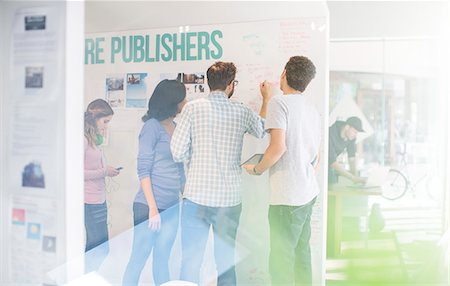 person writing on board - Publishers brainstorming at whiteboard in office Stock Photo - Premium Royalty-Free, Code: 6124-08170786