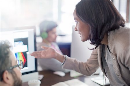 Creative businesswoman gesturing at computer in office Stock Photo - Premium Royalty-Free, Code: 6124-08170805