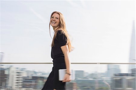 people walking in a city - Portrait laughing businesswoman with digital tablet on urban balcony Stock Photo - Premium Royalty-Free, Code: 6124-08520423