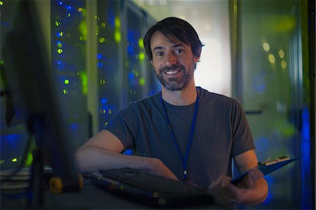 Portrait smiling server room technician with clipboard at computer Stock Photo - Premium Royalty-Free, Code: 6124-08658165