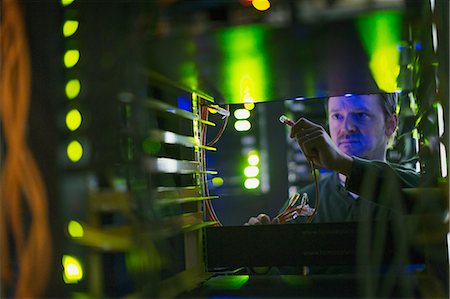 person in a server room - Server room technician with cable at panel Stock Photo - Premium Royalty-Free, Code: 6124-08658177