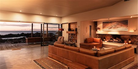 simsearch:6124-08658120,k - Home showcase interior living room overlooking ocean at sunset Stock Photo - Premium Royalty-Free, Code: 6124-08658121