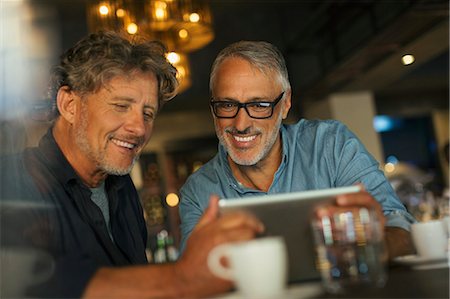 Men using digital tablet at restaurant table Stock Photo - Premium Royalty-Free, Code: 6124-08743180