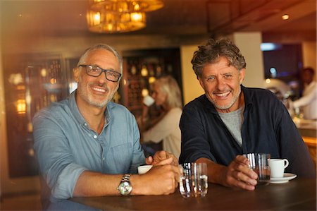Portrait smiling men drinking coffee and water at restaurant table Stock Photo - Premium Royalty-Free, Code: 6124-08743198